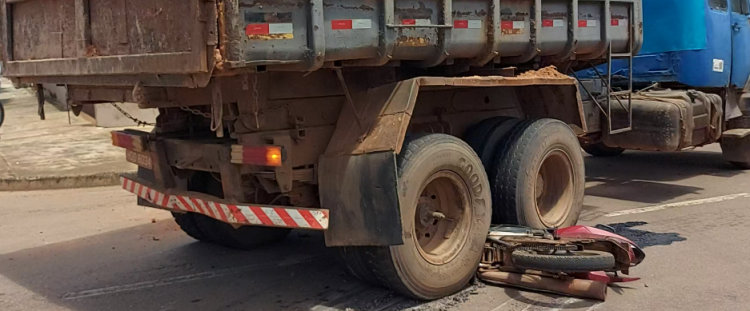 Moto fica presa embaixo de caminhão após acidente no Centro de Pontes e Lacerda